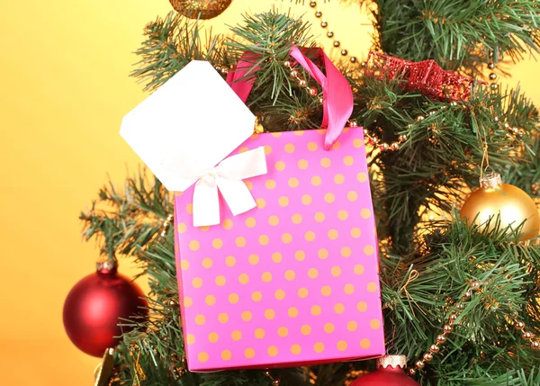 Gift on Christmas tree on color background — Stock Photo, Image