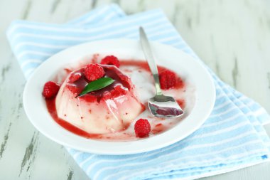Panna cotta ahşap zemin üzerinde frambuaz sos ile