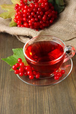 Bodegón con té de viburnum en servilleta de tela de saco, sobre fondo de madera
