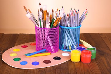 Composition of various creative tools on table on beige background clipart