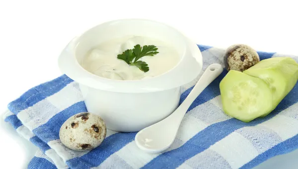 Yogurt al cetriolo in ciotola di vetro, su tovagliolo di colore, isolato su bianco — Foto Stock