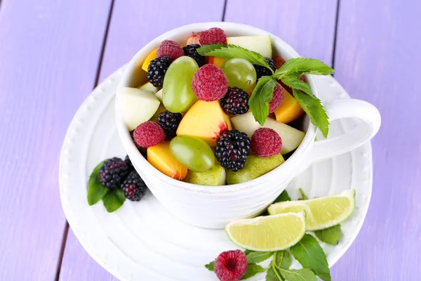 Obstsalat in Tasse auf Holztisch — Stockfoto