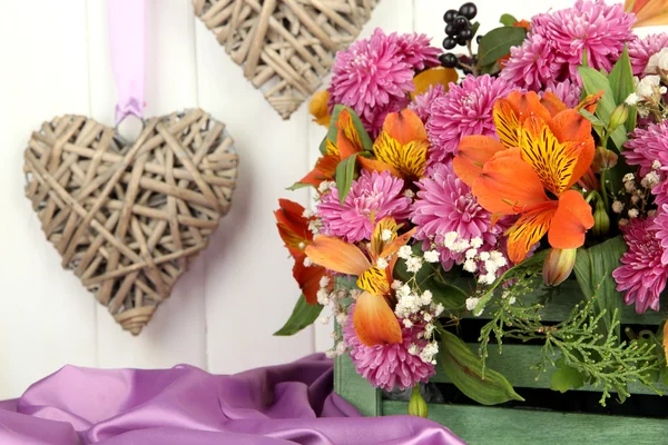 Composición de flores en cajón con corazones decorativos sobre mesa sobre fondo de madera — Foto de Stock