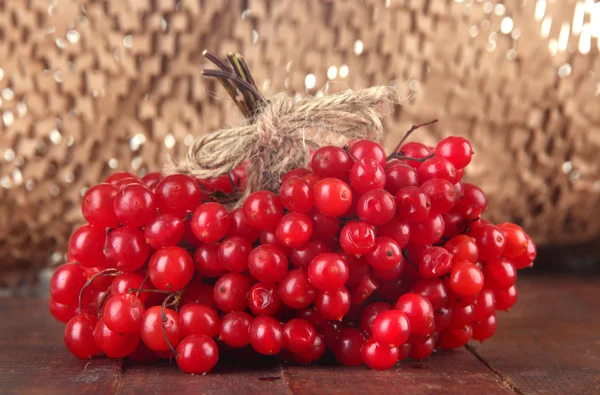 Red berries of viburnum on table on brown background — Stock Photo, Image