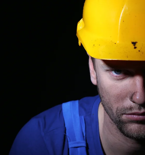 Porträt eines jungen Arbeiters auf dunklem Hintergrund — Stockfoto