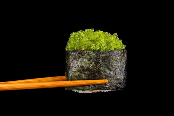 Проведение суши с палочками изолированы на черный — стоковое фото