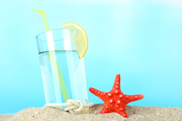 Strandcocktail im Sand auf blauem Hintergrund — Stockfoto