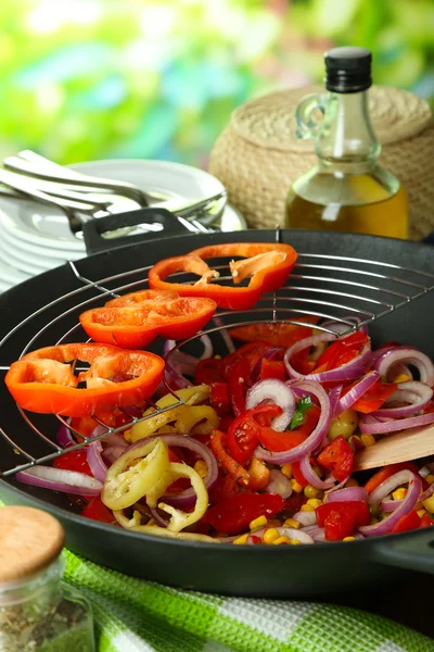 Vegetables in wok on wooden table on natural background — Stock Photo, Image