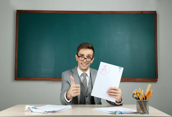 Unga lärare sitter i skola klassrum — Stockfoto