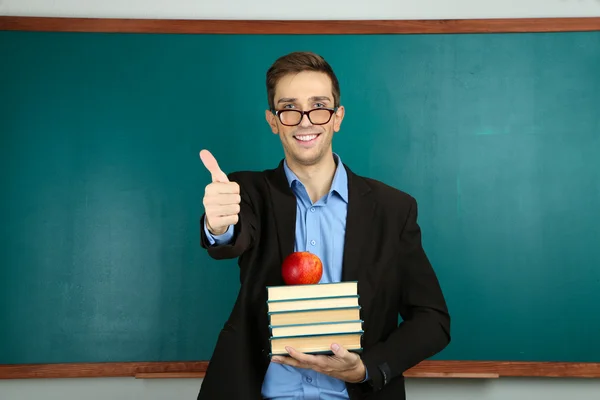 Young teacher near chalkboard in school classroom — Stock Photo, Image