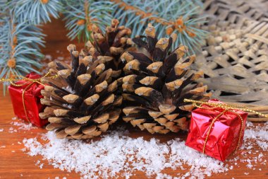 Ahşap arka planda çam kozalaklarıyla Noel süslemesi