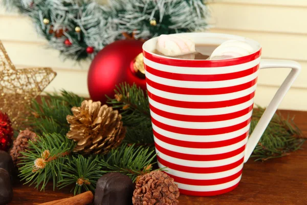 Copa de cacao caliente con chocolates y decoraciones de Navidad en la mesa sobre fondo de madera —  Fotos de Stock