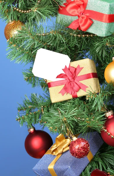 Geschenke am Weihnachtsbaum auf farbigem Hintergrund — Stockfoto