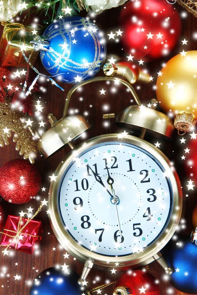 Reloj despertador con decoraciones navideñas sobre fondo de madera — Foto de Stock