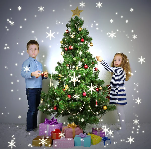 Kinder schmücken Weihnachtsbaum mit Kugeln im Zimmer — Stockfoto