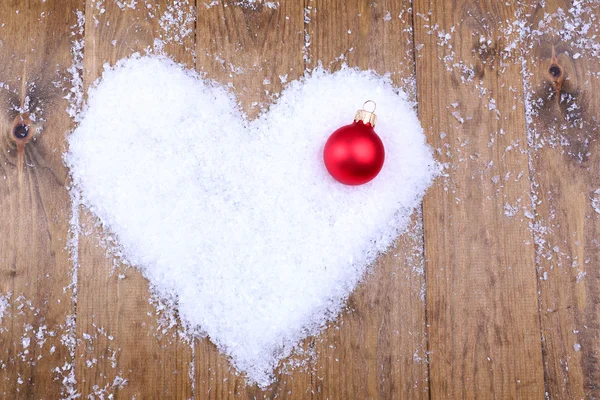 Cuore di neve con decorazioni, su sfondo di legno — Foto Stock