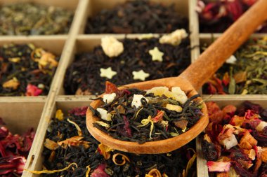 assortment of dry tea in wooden box, close up clipart