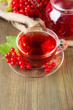 Bodegón con té de viburnum en servilleta de tela de saco, sobre fondo de madera