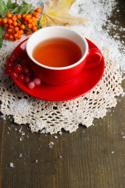 Turuncu kartopu çay Kupası, çilek ve ahşap zemin üzerinde kar ile natürmort