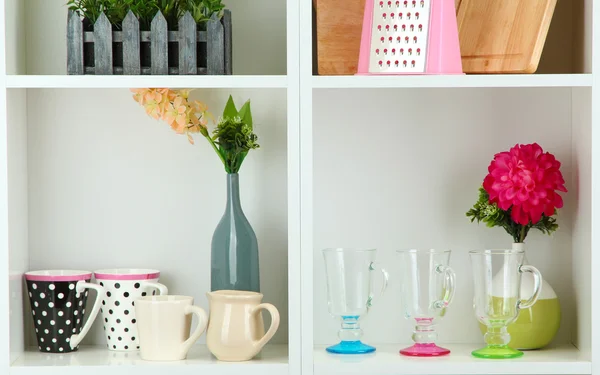 Beautiful white shelves with tableware and deco — Stock Photo, Image