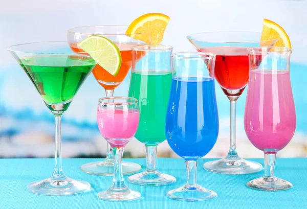 Glasses of cocktails on table near pool — Stock Photo, Image