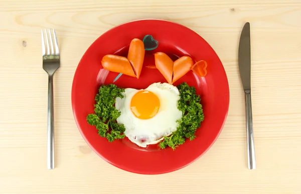 香肠在心、 炒鸡蛋和香菜上彩钢板、 木制背景上, 的形式 — 图库照片