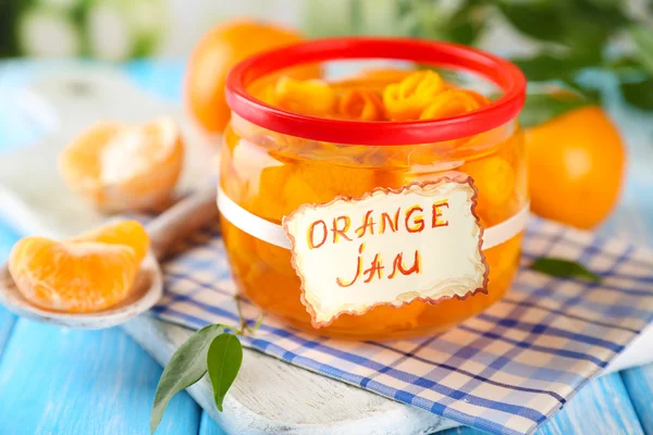 Engarrafamento de laranja com raspas e tangerinas, sobre mesa de madeira azul — Fotografia de Stock