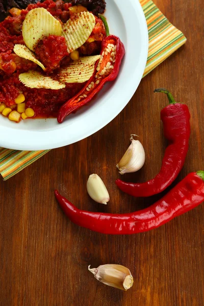 Chili Corn Carne - traditional mexican food, on white plate, on napkin, on wooden background