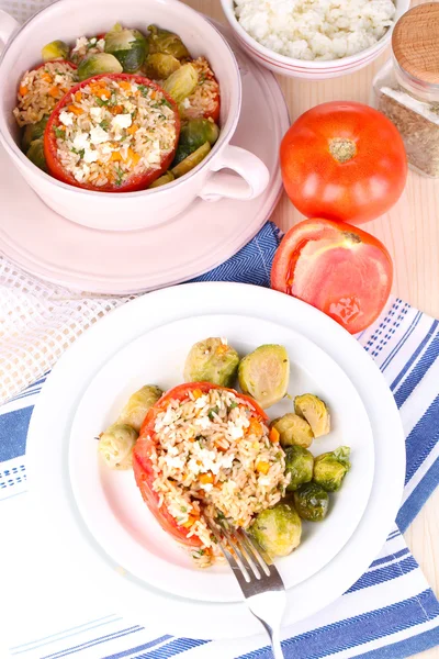 Tomates rellenos en plato y sartén sobre mesa de madera de cerca — Foto de Stock