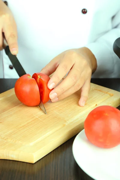 Mãos de cozinheiro corte de tomate — Fotografia de Stock