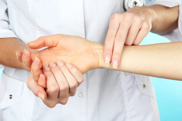 Measuring pulse on light blue background — Stock Photo, Image