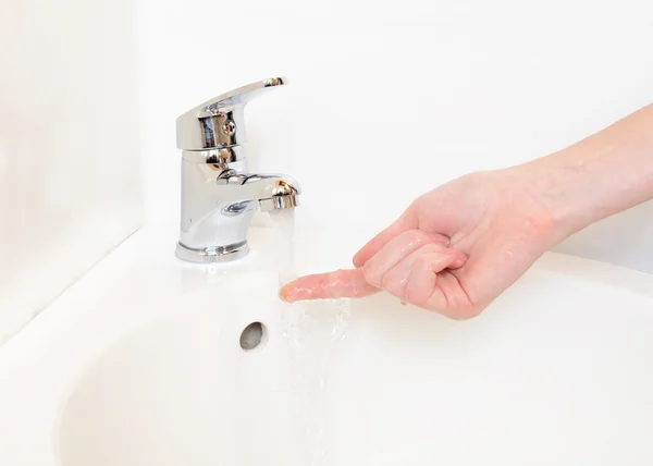 Primer plano de las manos humanas lavadas bajo el grifo en el baño, aisladas en blanco — Foto de Stock