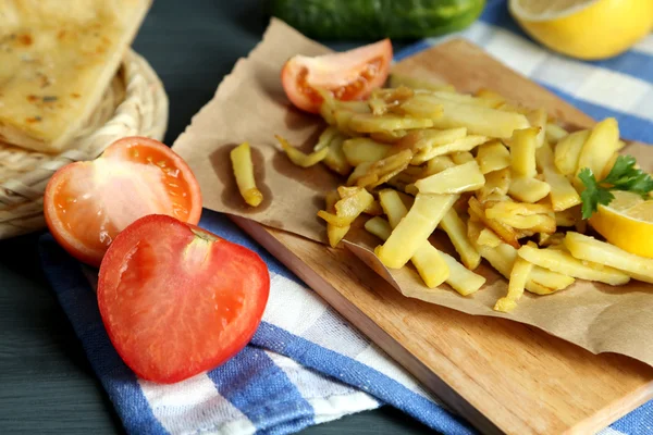 Patatas fritas Ruddy en tablero de madera en primer plano de mesa —  Fotos de Stock