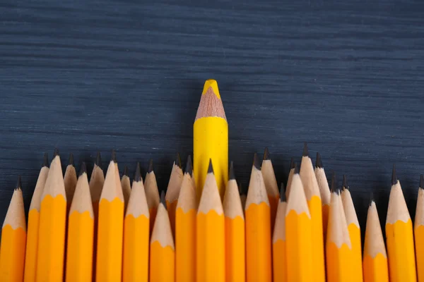 Celebratory pencil among usual pencils, on color background — Stock Photo, Image