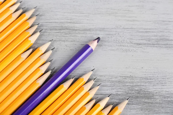 Celebratory pencil among usual pencils, on color background — Stock Photo, Image
