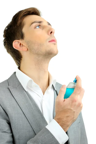 Bonito jovem usando perfume isolado no branco — Fotografia de Stock