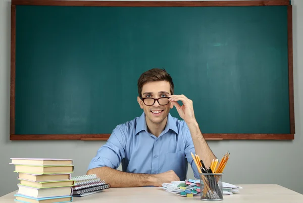 Joven profesor sentado en el aula de la escuela — Foto de Stock