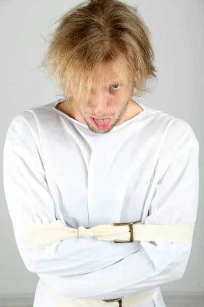 Homem mentalmente doente em camisa de força em fundo cinza — Fotografia de Stock