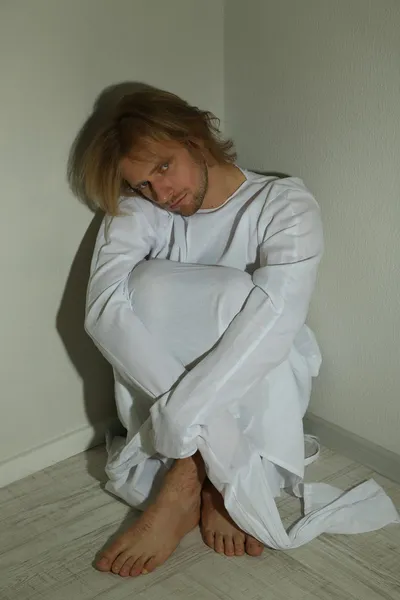 Hombre mentalmente enfermo con camisa de fuerza en la esquina de la habitación — Foto de Stock