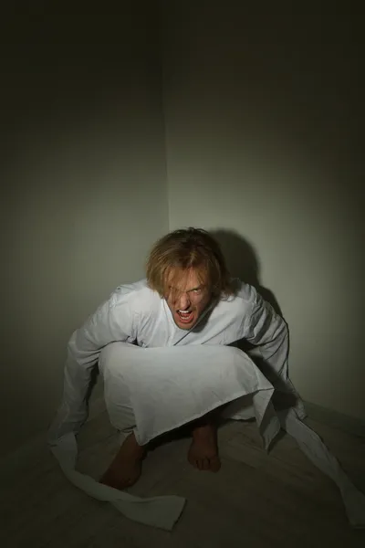 Mentally ill man in strait-jacket in room corner — Stock Photo, Image