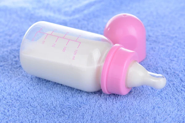 Kojenecká láhev s mlékem na ručník pozadí — Stock fotografie