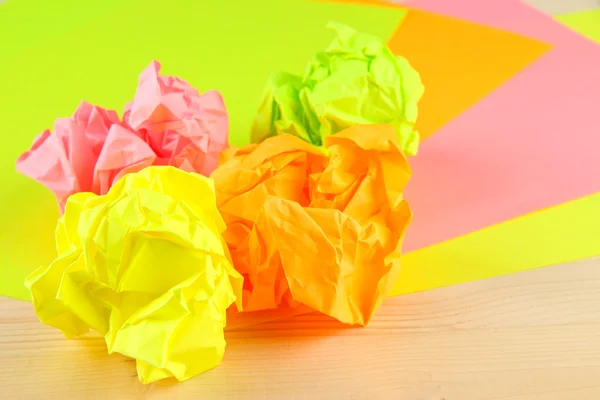 Bolas de papel amassadas coloridas no fundo de madeira — Fotografia de Stock