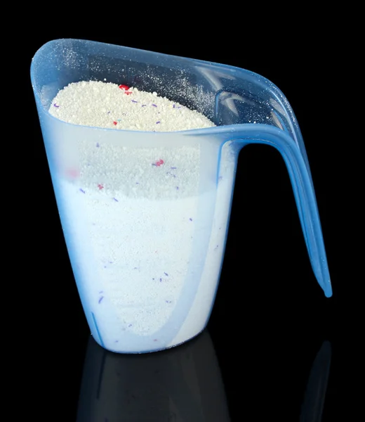 Washing powder in a measuring cup, isolated on black — Stock Photo, Image