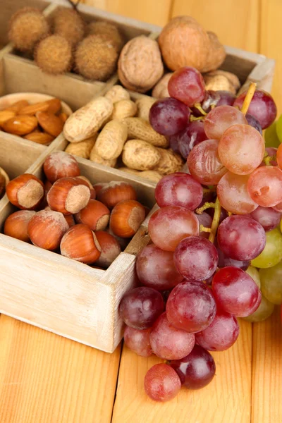 Grape with nuts on wooden table — Stockfoto