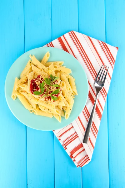Plato de pasta Rigatoni con salsa de tomate sobre mesa de madera azul — Foto de Stock
