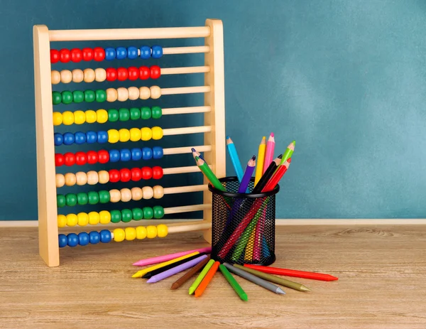 Toy abacus and pencils on table, on school desk background — Stock Photo, Image