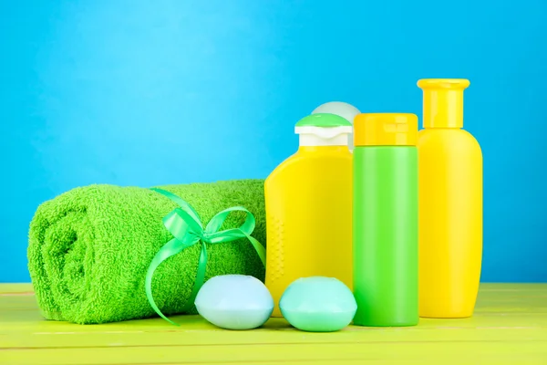 Kosmetyki dla dzieci, ręcznik i mydło na drewnianym stole, na niebieskim tle — Zdjęcie stockowe