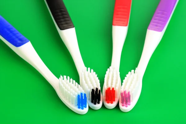 Tooth-brushes on green background — Stock Photo, Image