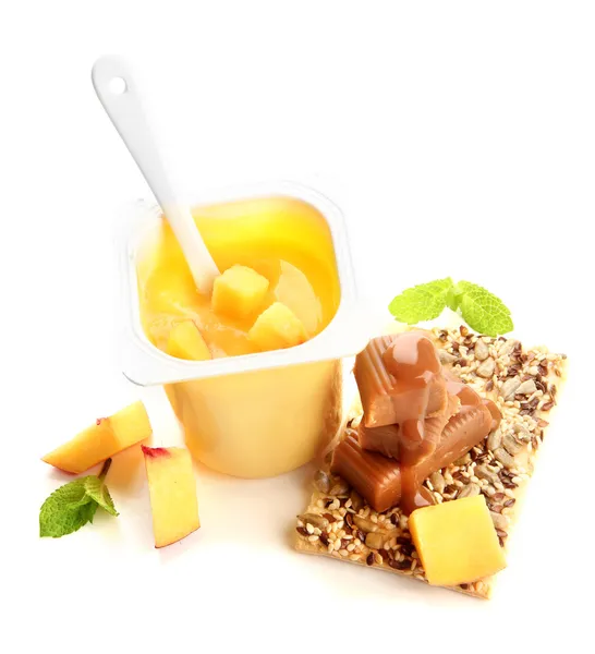 Läckra yoghurt med bitar av färsk frukt, kakor och Kola godis isolerad på vit — Stockfoto