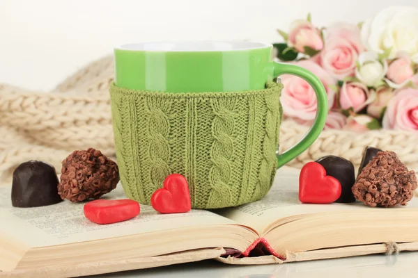 Tasse mit Stricksachen darauf und aufgeschlagenem Buch in Nahaufnahme — Stockfoto